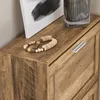 A close-up shot of the top surface of a wooden cabinet, showing a decorative beaded bracelet and a portion of a framed artwork. Voir les images du produit