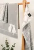 Two towels with a cat pattern are displayed on a wooden rack. Produktbild-Vorschau