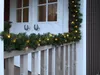 A decorated doorway with Christmas garland and lights. Produktbild-Vorschau