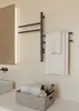 A modern bathroom scene featuring a black electric towel warmer with towels hanging on it, a sink, and a basket of toiletries on the counter. Náhľad obrázku produktu