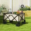 A garden wagon filled with flowers and gardening tools sits on a grassy lawn in front of a white picket fence and a raised garden bed. Produktbild-Vorschau