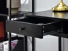 A close-up view of an open black drawer on a black desk, with a metal drawer slide visible. Voir les images du produit