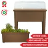 A raised garden bed with a clear lid and a separate planter box filled with herbs and plants, set against a white background. Promotional text overlays are present. Produktbild-Vorschau