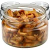 Three glass jars filled with preserved mushrooms, with the front jar in focus. Podgląd zdjęcia produktu