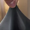 A hand is shown stretching a piece of dark gray fabric. Náhled obrázku produktu