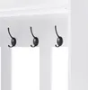 A close-up view of three black coat hooks mounted on a white panel. Produktbild-Vorschau