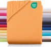 A folded orange fitted sheet is shown with a stack of other colored sheets in the background. A green OEKO-TEX logo is visible in the top right corner. Produktbild-Vorschau