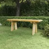 A wooden bench sits on a grassy lawn in front of a dense green hedge and a tree. Anteprima dell’immagine prodotto