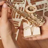 Hands assembling a wooden 3D puzzle of a saxophone. Náhľad obrázku produktu