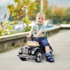 A young child is riding a toy car outdoors. Podgląd zdjęcia produktu