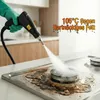 A hand wearing a green glove is using a black steam cleaner to clean a very dirty stovetop. Produktbild-Vorschau