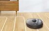 A robotic vacuum cleaner is shown cleaning a wooden floor, with a white dashed line indicating its cleaning path. Náhľad obrázku produktu