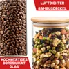 Zwei klare Glas-Vorratsgläser mit hellbraunen Bambusdeckeln, eines gefüllt mit Kaffeebohnen, das andere mit Nüssen und Trockenfrüchten Produktbild-Vorschau