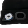 A close-up view of a black beanie with a detachable LED light and a separate black ring attachment. Produktbild-Vorschau