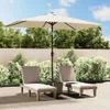 Two lounge chairs and a patio umbrella are set up on a paved patio area, surrounded by lush green bushes and trees, with a wooden fence in the background under a partly cloudy sky. Podgląd zdjęcia produktu