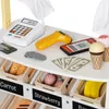 A close-up view of a toy cash register and accessories on a white surface, with toy food items in drawers below. Náhľad obrázku produktu