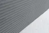 A close-up view of a gray, ribbed fabric surface meeting a white, quilted surface, likely a mattress or bedding. Produktbild-Vorschau