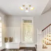 A hallway with a bench, window, and staircase, illuminated by a ceiling light. Voir les images du produit