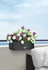 A balcony planter box filled with flowers, overlooking the ocean and sky. Produktbild-Vorschau