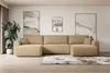 A modern living room with a large beige sectional sofa, abstract art on the wall, and a potted plant.