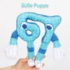 A plush toy shaped like the numbers 6 and 7 is held up against a white background. The toy is blue with a checkered pattern and has arms and legs. Produktbild-Vorschau