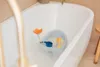 A baby bath seat with toys inside a bathtub filled with bubbly water. Produktbild-Vorschau