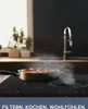 A cooking scene with a pan on an induction cooktop, with steam rising. Produktbild-Vorschau