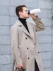 A man in a trench coat drinks from a white thermos. Anteprima dell’immagine prodotto