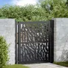 A black metal garden gate with a decorative trace design, set between two brick pillars, with lush green foliage in the background. Podgląd zdjęcia produktu