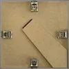 The back of a picture frame showing the backing board and clips. Produktbild-Vorschau
