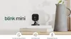 A Blink Mini camera is displayed on a shelf with books and a vase, accompanied by feature icons and text. Podgląd zdjęcia produktu