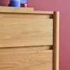 Close-up of a wooden dresser with two drawers, with a book and decorative items on top. Produktbild-Vorschau