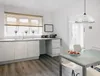 A modern kitchen with white cabinets, a dining table, and a pendant light. Produktbild-Vorschau