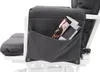 Close-up of a dark gray fabric pocket on the side of a white chair, holding magazines. Produktbild-Vorschau