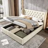A bedroom scene with a bed that has its storage compartment open, revealing stored items. Produktbild-Vorschau