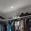 A closet interior with shelves filled with clothes and shoes. Produktbild-Vorschau