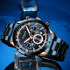 A close-up studio shot of a men's wristwatch with a blue dial and gold accents, placed on a clear cube against a blue background. Produktbild-Vorschau