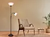 A floor lamp and an armchair in a room. Náhled obrázku produktu