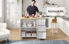 A man in a chef's uniform stands behind a kitchen island in a modern kitchen. Podgląd zdjęcia produktu