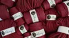 A pile of red yarn spools with labels. Náhled obrázku produktu
