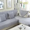 Heller grauer gesteppter Sofabezug für Sektionalsofas mit passenden Wurfkissen auf einem beigen Sofa im Wohnzimmer Náhľad obrázku produktu