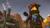 A Lego character stands in front of a factory with smoke stacks. Náhled obrázku produktu