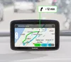 A GPS navigation device mounted on a car dashboard, showing an alternative route with time savings. Podgląd zdjęcia produktu