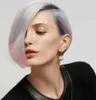 A woman with short, multi-colored hair and a black top, wearing earrings. Anteprima dell’immagine prodotto