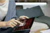 A person is using a tablet device indoors, possibly in a living room or bedroom setting. Podgląd zdjęcia produktu