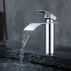 A chrome waterfall faucet is shown in operation, with water flowing into a dark stone basin. Produktbild-Vorschau