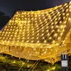 A tent covered in warm white net lights at night. Produktbild-Vorschau