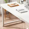 A close-up view of a white desk with books and a laptop on it. Podgląd zdjęcia produktu