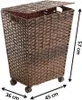 A brown wicker laundry basket with a lid and wheels, shown with dimensions indicated by measurement lines and text. Náhled obrázku produktu