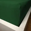 A close-up view of a dark green fitted sheet on a white bed frame. Náhled obrázku produktu